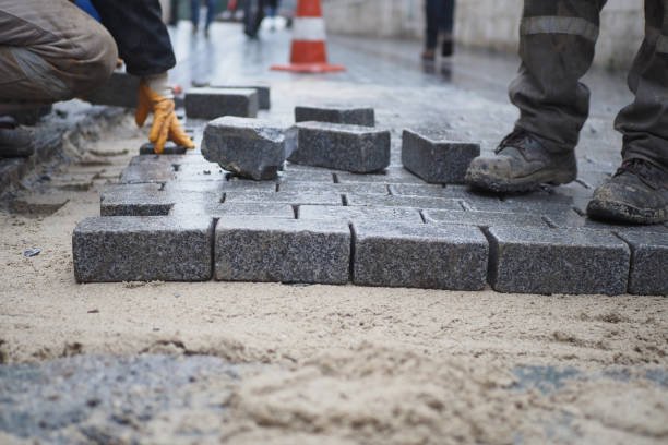 A man laying bricks on a sidewalk, for top-notch concrete services