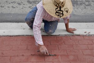 A concrete contractor in Dallas, GA polishing a freshly finished concrete surface under the sun, showcasing expert craftsmanship.