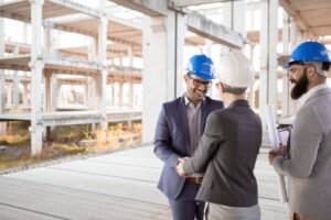 Three individuals in hard hats discussing a project at a Metro Atlanta construction site, reflecting trust in custom concrete work.
