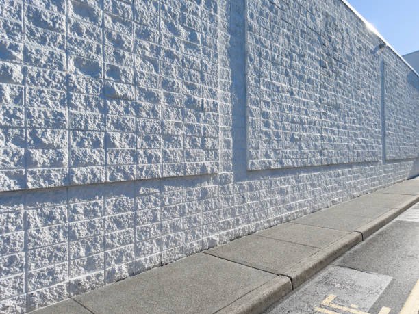 A white concrete wall alongside a street, providing a clean and simple urban backdrop.