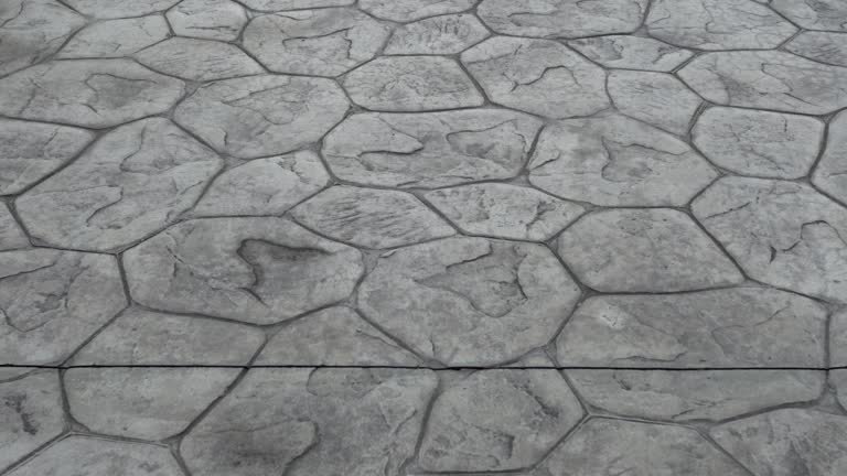 Stamped concrete patio featuring a cozy fire pit and an elegant water feature, creating a serene outdoor space.