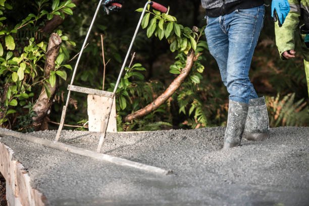 A concrete contractor uses a mixer to create a concrete path, focusing on driveways, patios, and foundations.