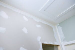 A white wall and ceiling, both featuring smooth, even white paint, indicating recent drywall repair Near Me