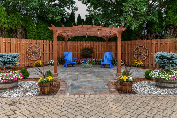 A backyard scene showcasing a pergola and wooden fence, highlighting patio construction options available Contractors Near Mableton GA