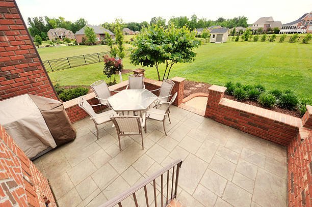 A patio featuring a table and chairs, set on a textured stamped concrete surface.