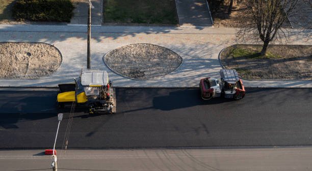 View of a construction site with a truck and tractor, highlighting work on commercial driveway paving.