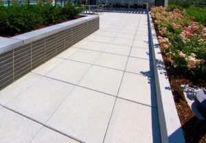 A commercial walkway adorned with colorful flowers and a wooden bench for resting.